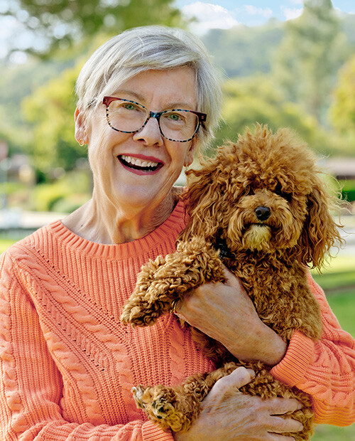 Senior woman holding a small brown dog